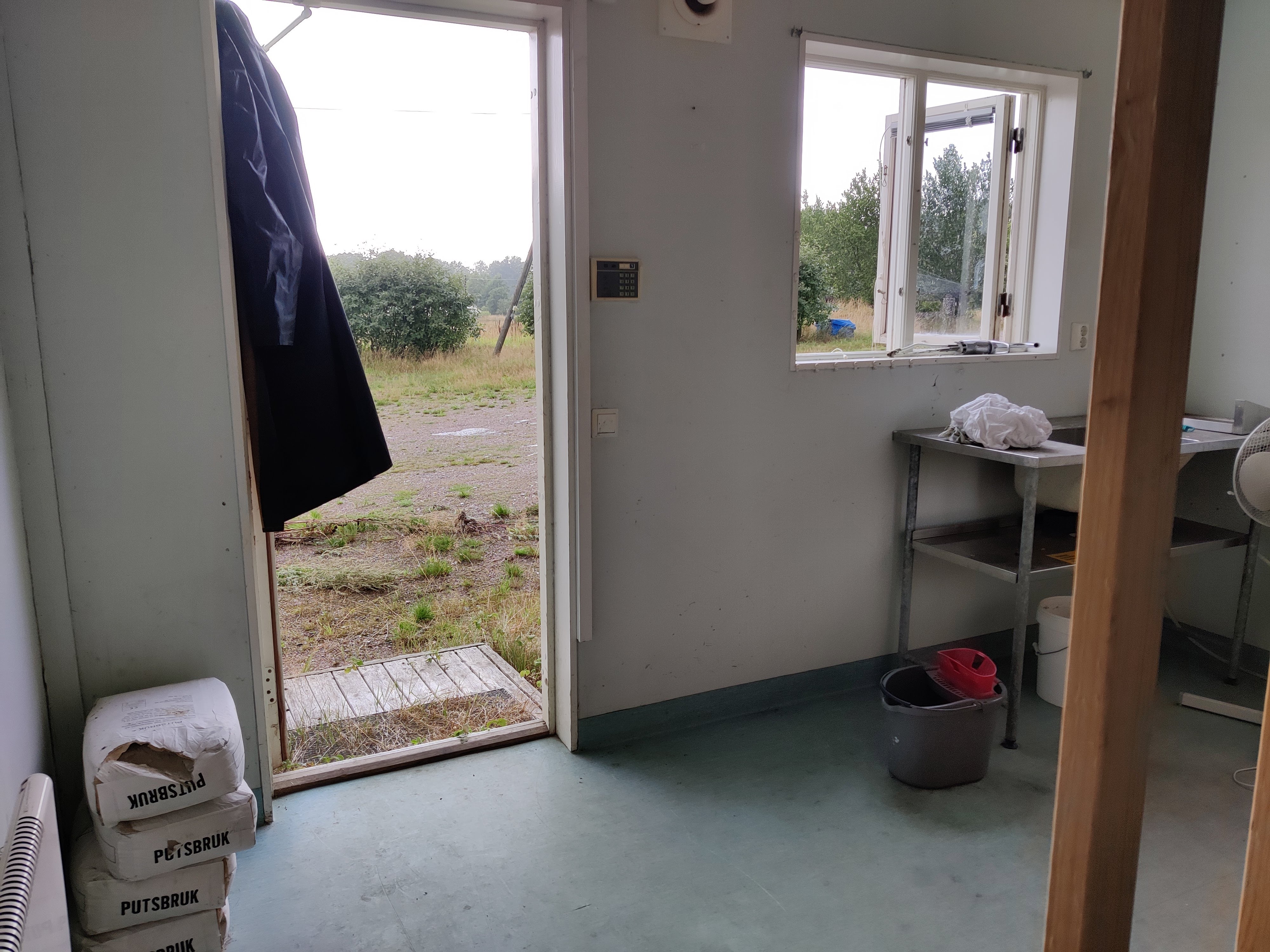 Ett kalt, smutsigt rum. En diskbänk och några påsar cement.